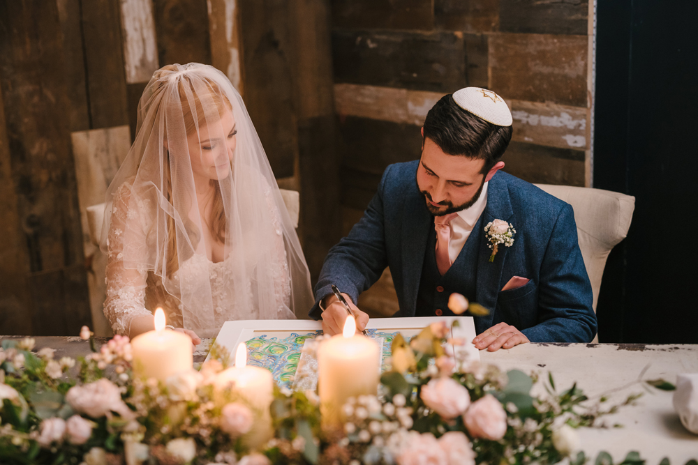 An image of a couple deeply engrossed in personalizing their Ketubah design